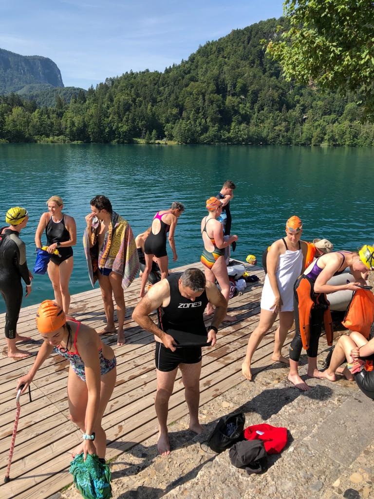 dock on the island in the lake. A group of swimmers hanging out in their swimsuits and drying off.