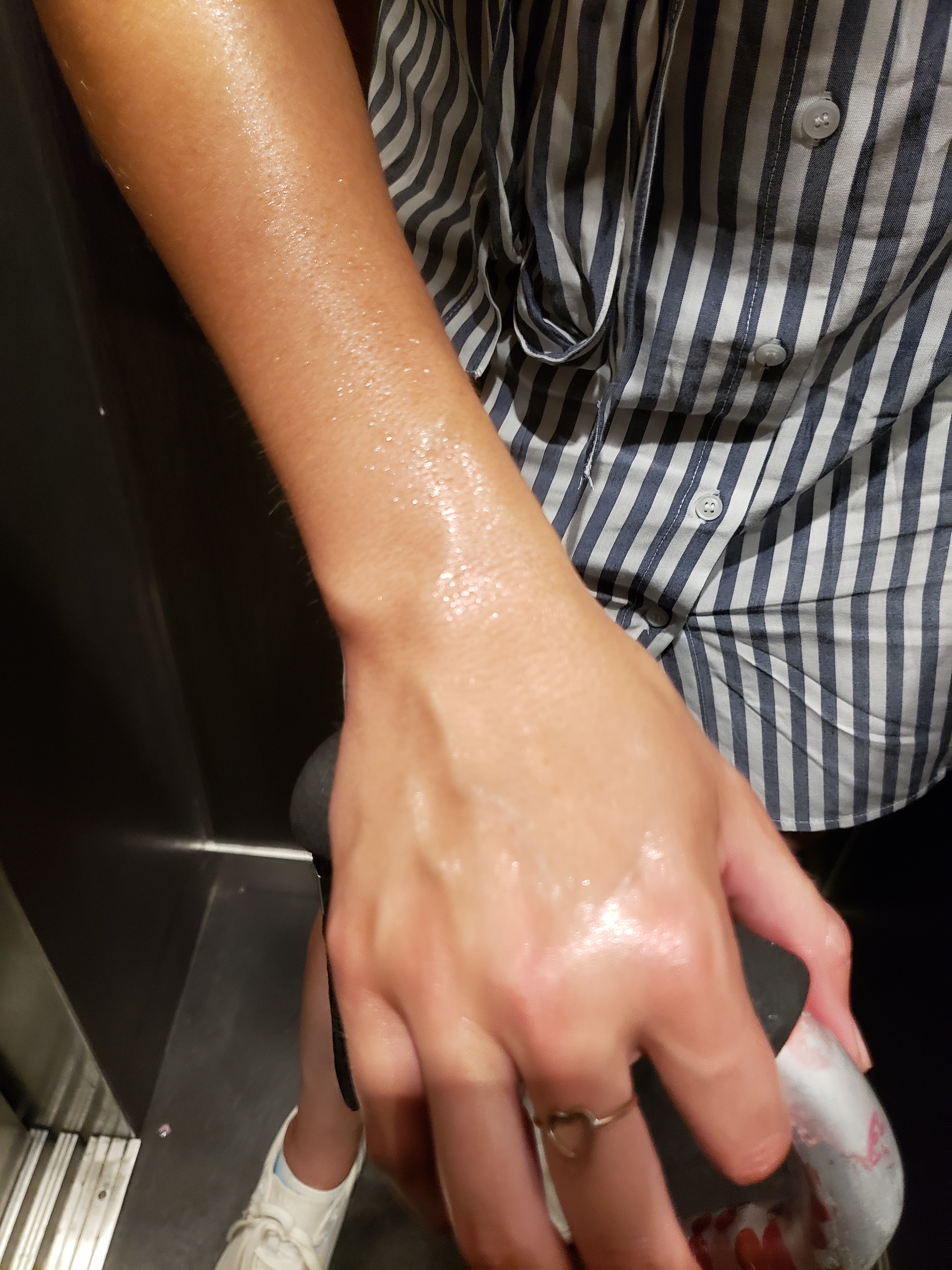 Photo of my sweaty hand holding my cane as we ride up the elevator