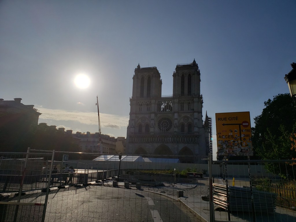 Notre Dame in the background thanks to a construction fence blocking access. The sun is to the left of the Notre Dame