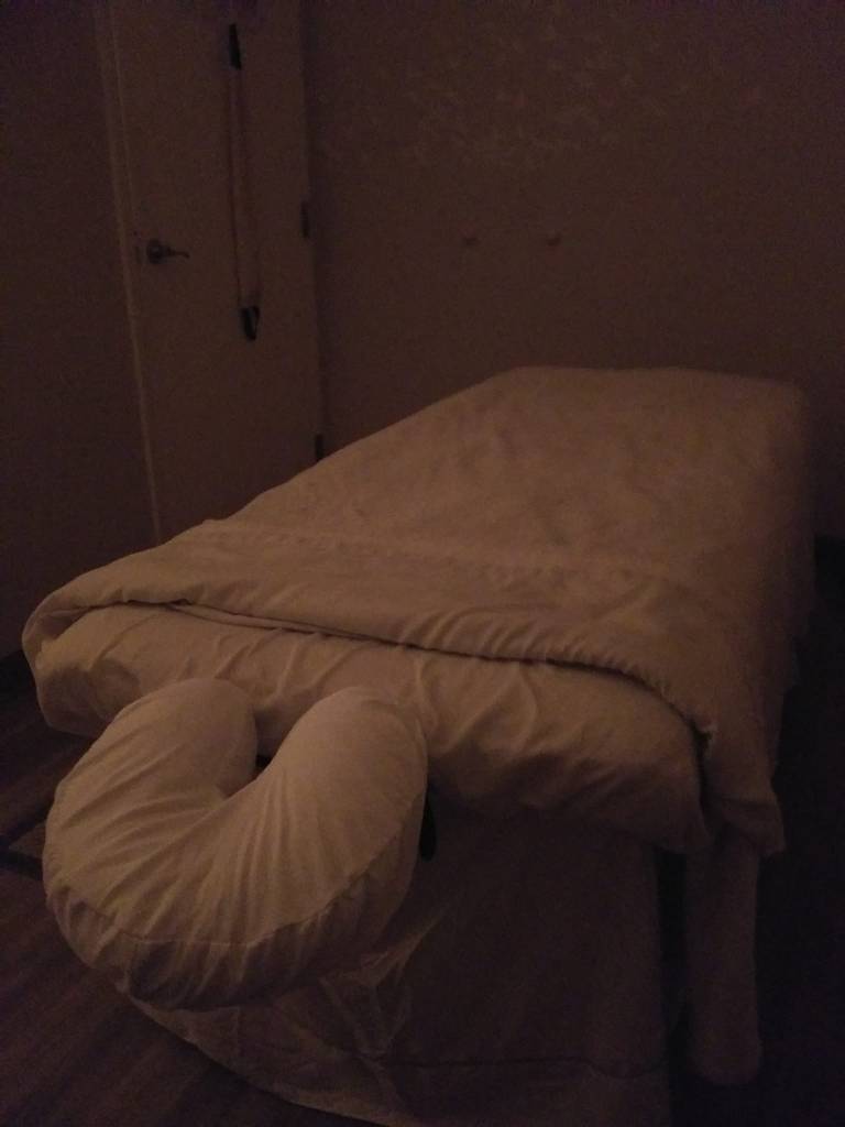 Dimly lit room with a massage table.